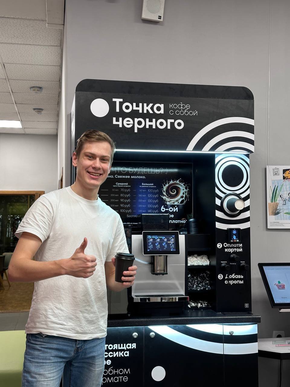 партнёр «Точки Чёрного» с напитком у своей кофейной стойки